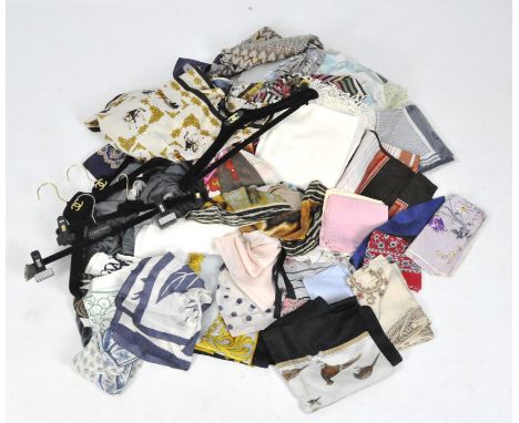 A collection of assorted designed fabrics and wares, including Hermes style scarves, Chanel hangers and more