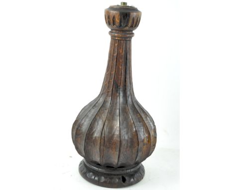 A carved wooden lamp base, of bottle form, raised on a circular base, height 34cm