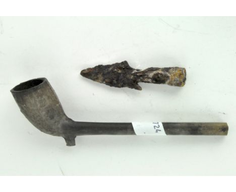 An antique metal arrow head, together with a plaster pipe decorated with vines