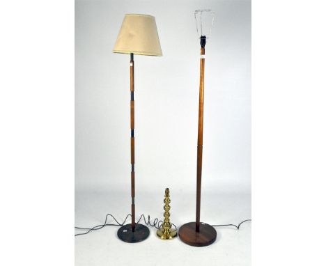 A vintage brass table lamp, 38cm high, together with two wooden standard lamps, 138cm high (excluding the fittings)