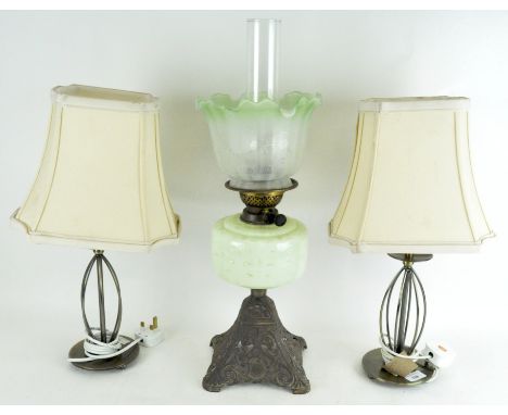 An Edwardian oil lamp with etched green glass shade, together with two modern table lamps on gilt-metal base, the first 58cm 