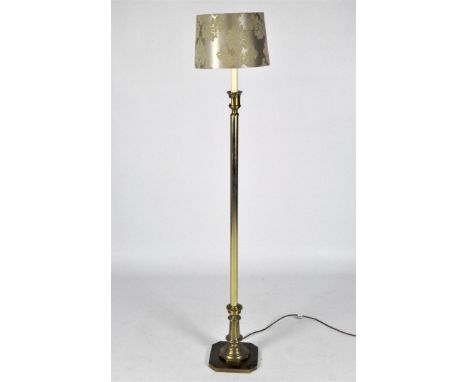 A vintage brass standard lamp on an octagonal base with candlestick fitting and beige lampshade, height 122cm