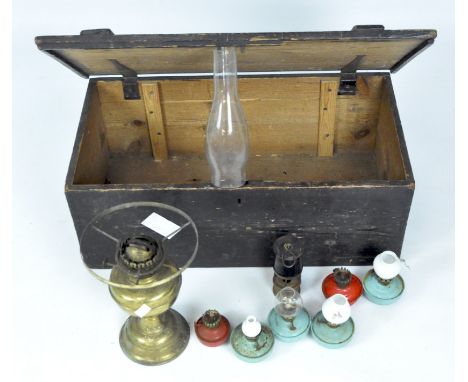 A Victorian brass oil lamp and assorted accessories in a hinged wooden trunk
