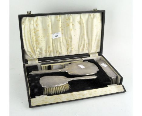 A silver mounted Art Deco dressing table set, comprising a mirror, two brushes and a comb, within a fitted black velvet lined