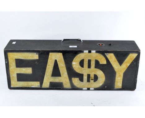 A portable black tube light cased in a black wooden box with sprayed gold letters to the front reading EA$Y, 23.5cm x 69cm x 