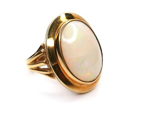 A modern 18ct yellow gold and opal dress ring, the oval cabochon opal in rubover setting, 17 by 12 by 6mm, maker 'DOM', size 