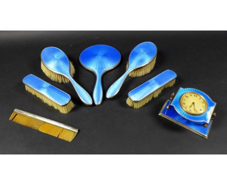 An Art Deco dressing table set, with blue enamel decoration, comprising a hand mirror, two hair brushes, two clothes brushes,