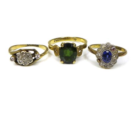 A group of three 18ct gold dress rings, comprising an 18ct gold sapphire and diamond cluster ring, central oval cut sapphire 