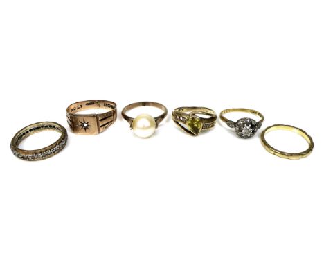 A group of six gold and yellow metal dress rings, including a 9ct gold gypsy ring, size S, 2.6g, missing its central stone, a