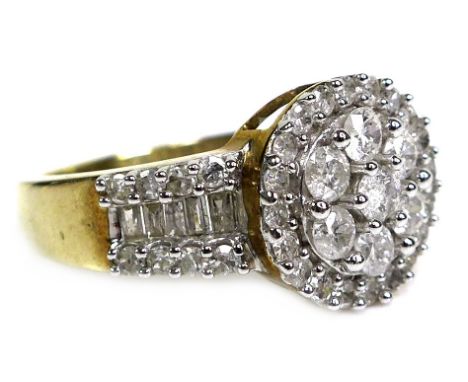 A 9ct yellow gold and diamond ring, of target form with wide tapering shoulders, set centrally with a flowerhead of seven rou