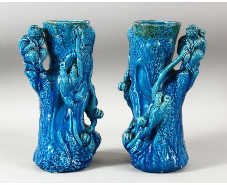 A PAIR OF CHINESE TURQUOISE GLAZED POTTERY MONKEY VASES, the body of each formed as a tree trunk with climbing monkeys, each 