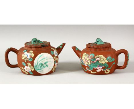 TWO CHINESE YIXING CLAY TEAPOTS WITH POLY CHROME DECORATION- the pots decorated depicting panels of flora &amp; lion dogs, th