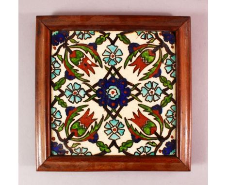 A FRAMED IZNIK STYLE POTTERY TILE SECTION, with a floral motif decoration, 26cm