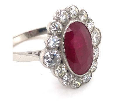 A RUBY AND DIAMOND OVAL CLUSTER RING. UNHALLMARKED, ASSESSED AS PLATINUM. FINGER SIZE N. WEIGHT 6.42grms. 