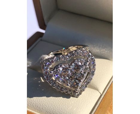 A LARGE MULTI DIAMOND HEART SHAPED RING UPON TRIPLE OPEN DIAMOND SHOULDERS. UNHALLMARKED, STAMPED 9K, ASSESSED AS 9ct WHITE G