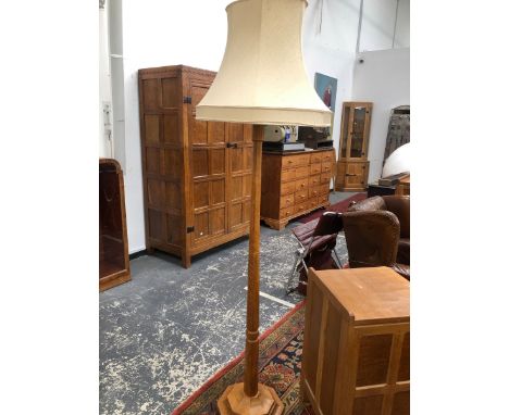 A ROBERT MOUSEMAN THOMPSON OAK STANDARD LAMP, THE OCTAGONAL COLUMN FLARING TO A STEPPED FOOT. 