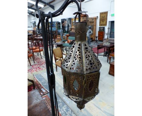 AN 19th CENTURY EASTERN  STYLE BRASS LANTERN SUSPENDED AS A STANDARD LAMP FROM AND ADJUSTABLE ON AN IRON COLUMN ON Y-SHAPED F