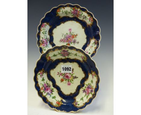 A PAIR OF FIRST PERIOD WORCESTER BLUE SCALE PLATES, EACH PAINTED WITH GOLD FRAMED RESERVES OF FLOWERS, SEAL MARKS IN BLUE.   