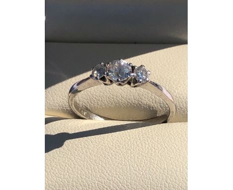 A THREE STONE DIAMOND RING. UNHALLMARKED, STAMPED PLAT, ASSESSED AS PLATINUM. FINGER SIZE R. WEIGHT 3.5grms.