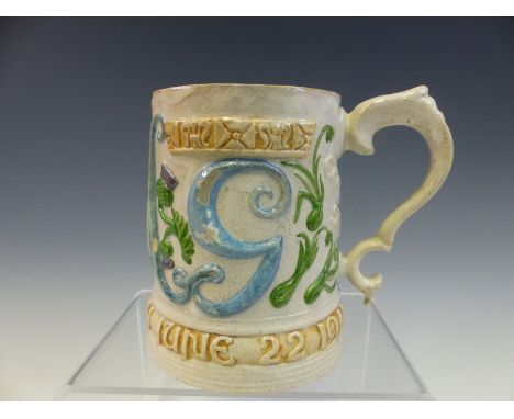 A COMPTON POTTERY CORONATION MUG FOR GEORGE V AND QUEEN MARY MOULDED IN RELIEF WITH THEIR INITIALS WITH THE FOUR NATIONS PLAN