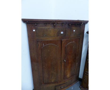 A GEORGE III MAHOGANY BOW FRONT CORNER CUPBOARD, THE ROUND ARCH PANELLED DOORS ABOVE A SMALL DRAWER.   W 99 x 123.5cms.