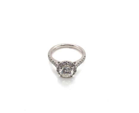 A HALLMARKED PLATINUM AND DIAMOND RING. THE PRINCIPLE DIAMOND APPROX 1.06cts, h colour, SI2. THE HALO AND SHOULDERS APPROX 0.