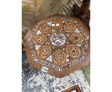 AN ISLAMIC OCTAGONAL TABLE, THE TOP GEOMETRICALLY INLAID IN MOTHER OF PEARL AND TWO TONES OF WOOD ABOUT A CENTRAL INSCRIPTION