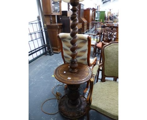 AN OAK SPIRAL TWIST STANDARD LAMP, THE COLUMN ABOVE A CIRCULAR TABLE TOP ON A FOLIATE CARVED CIRCULAR FOOT