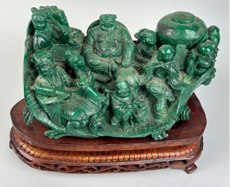 A CHINESE MALACHITE SCULPTURE DEPICTING A BUDDHA WITH FIGURES PLAYING MUSICAL INSTRUMENTS, 30cm x 18cm x 15cm Mounted on a wo