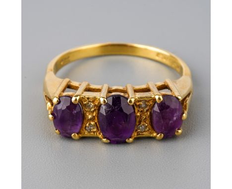 An 18ct yellow gold and amethyst three-stone ring, set with three oval mixed-cut amethyst, diamond chip highlights, size Q, t