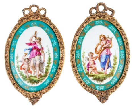 A pair of hand painted porcelain panels with maidens and cherubs playing music. Frames measure approx. 25 x15.5 cm  Some wear