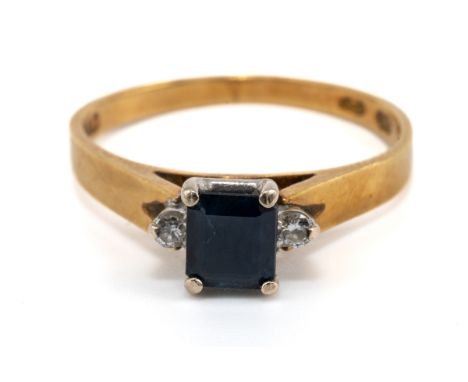 A gold sapphire and diamond ring, the central square-cut sapphire flanked by two round brilliant -cut diamonds, in white gold