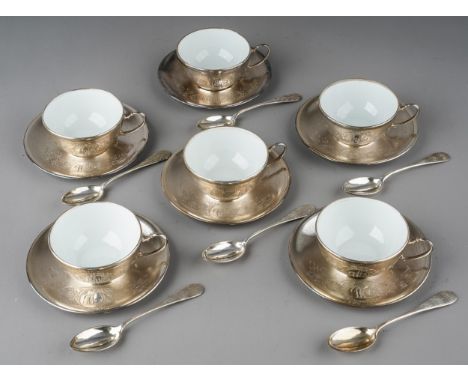 A set of six Continental white metal mounted ceramic coffee cups with matching white metal saucers and spoons, each engraved 