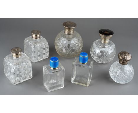 A collection of seven silver mounted cut glass scent bottles, including a matched pair of Art Deco rectangular bottles, one w