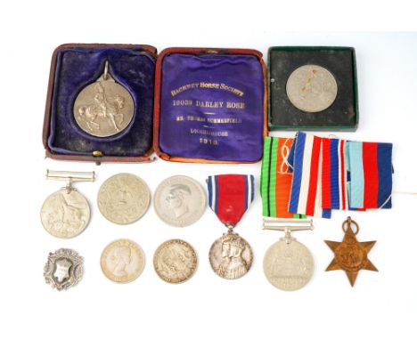 A World War II trio of medals, unnamed; a George V and Queen Mary 1910-1935 Jubilee medal; a silver Hackney Horse Society med