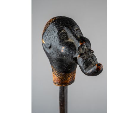 An unusual tribal carved sword stick, in the form of a man with something in his mouth, incised carved decoration and name, t