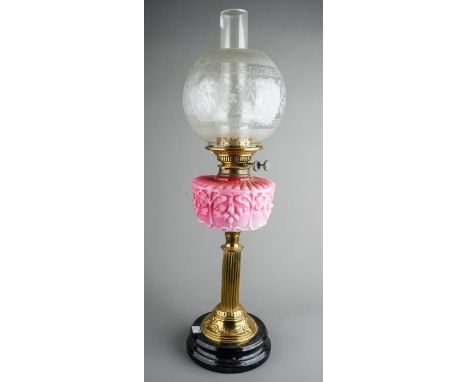 A Victorian style brass oil lamp on reeded column base, with pink moulded glass reserve, etched glass globular shade with flo