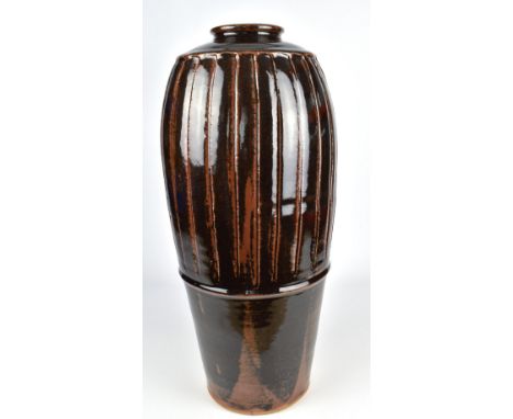 JIM MALONE (born 1946); a tall fluted stoneware bottle covered in tenmoku breaking to kaki glaze, impressed JM and L (for Les