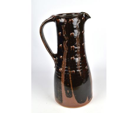 JIM MALONE (born 1946); a tall stoneware jug covered in tenmoku breaking to kaki glaze, impressed JM and A (for Ainstable) ma