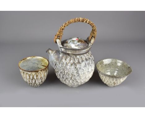 AKIKO HIRAI (born 1970); a dry kohiki stoneware teapot with willow handle and two matching bowls, painted marks to bowls, tea