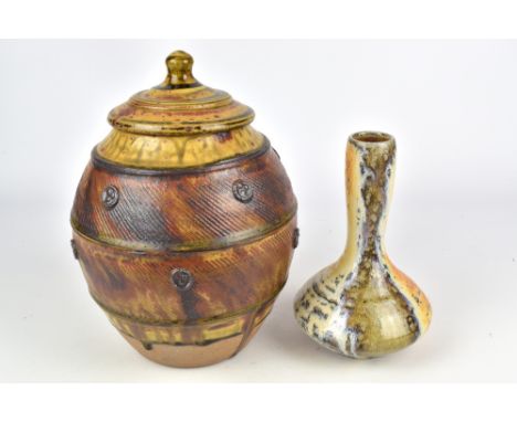JOHN JELFS (born 1946); a stoneware jar and cover with bands of linear decoration and medallions and a wood fired bottle, imp