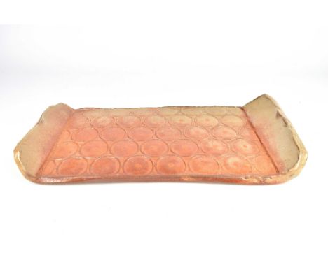 SHELBY SMITH; a large stoneware tray with impressed circle pattern covered in shino glaze, 46 x 24cm.Based in Hawaii, Smith t
