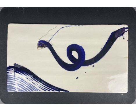 ADAM CHAU; a porcelain tile with cobalt painted dragon, gold lacquer repair to one edge, painted signature, 47 x 26cm.Chau co