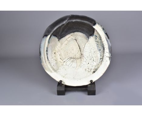 CLAUDE CHAMPY (born 1944); a stoneware plate partially covered in white crackle slip with pinkish hues, incised signature, di