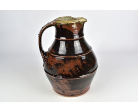 JIM MALONE (born 1946); a stoneware bellied jug covered in tenmoku breaking to kaki glaze with ash top, impressed JM and L (f