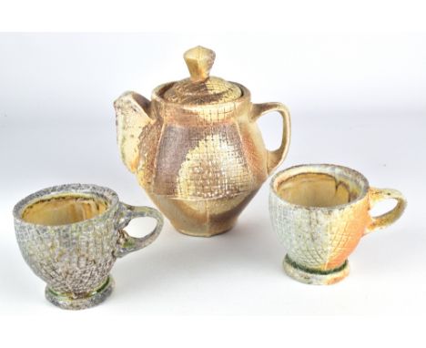 SAM CHUMLEY; a wood fired stoneware teapot and matching pair of cups, impressed S mark to teapot, tallest height 17cm (3).Chu