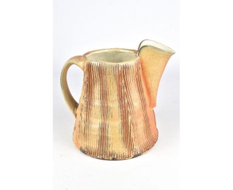 MATT KELLEHER; a soda fired earthenware pitcher with linear decoration and tin glazed interior, impressed M mark, height 18cm