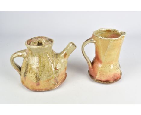 ANASTASIA SIMMONS; a faceted wood fired stoneware teapot and a matching jug, tallest 15.5cm (2). (D)Provenance: Purchased at 