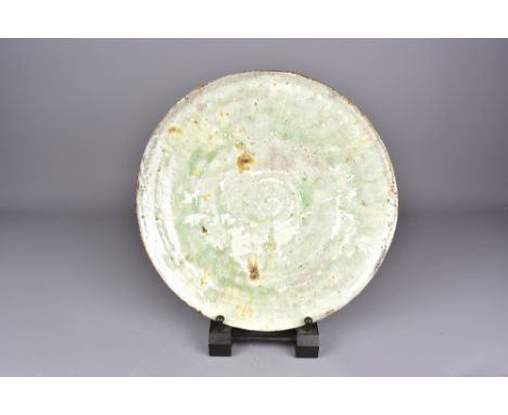 AKIKO HIRAI (born 1970); a stoneware platter covered in lime green glaze, diameter 35cm.Provenance: Purchased at Oxford Ceram