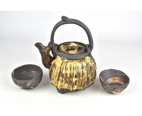RUTHANNE TUDBALL (born 1948); a faceted soda glazed stoneware teapot and a pair of cups, impressed marks, tallest 21.5cm (3).